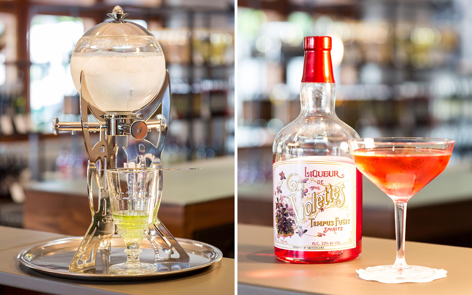 Absinthe-Fontäne steht auf Bartresen. Glas mit eingeschenktem orangefarbigem Liqueur des Violettes steht neben dazugehöriger Flasche.