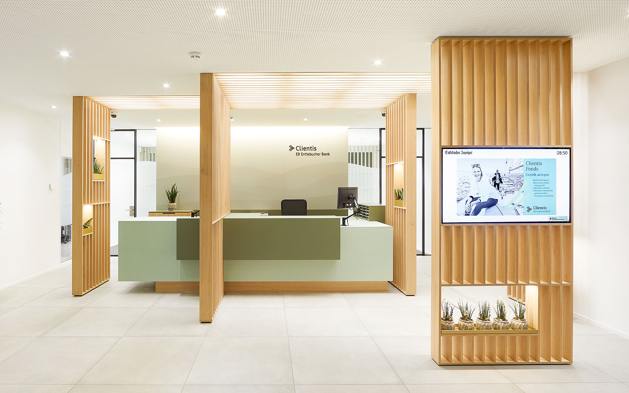 Innenarchitektur der Beraterbank. Frontansicht des Kundenschalters. Ein Bildschirm und Pflanzen wurden in die Holzlamellenwände integriert.
