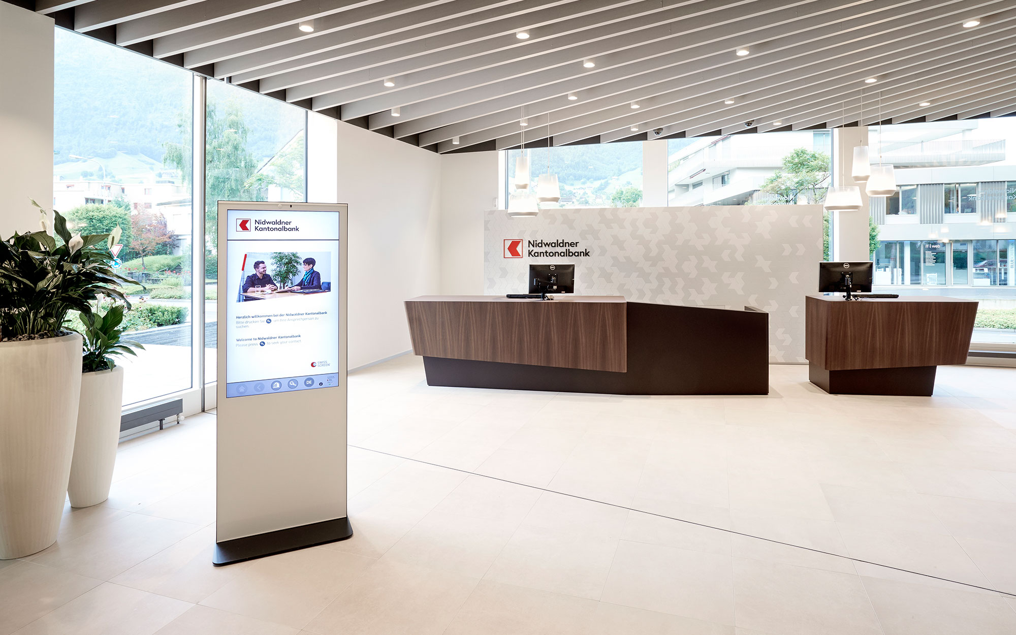 Videoanmeldung in der Bank an einem Bildschirm im Eingangsbereich